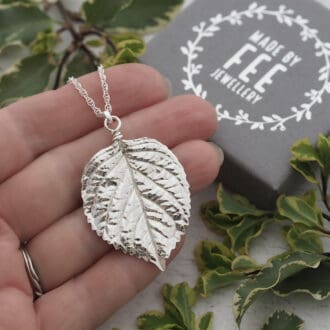 Large statement fine silver real hydrangea leaf pendant on a sterling silver rope chain shown on the hand with grey Made By Fee branded jewellery box