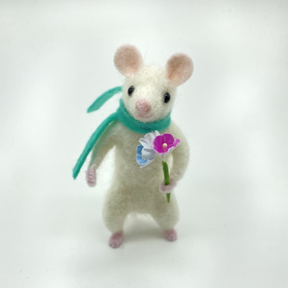 Needle felted white mouse holding a colorful bouquet of paper flowers with a green scarf