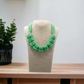 Neon green knotted rope statement necklace shown on a bust model against a light background.