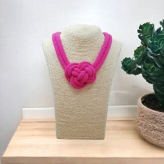 Pink chunky rope statement necklace shown on a light bust model against a light background