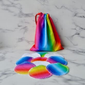 Reusable cotton pads with matching storage bag. Fabric is striped in rainbow colours.