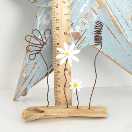 Wire and clay flowers set on a piece of driftwood, handmade ornament