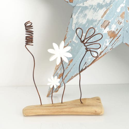 Wire and clay flowers set on a piece of driftwood, handmade ornament