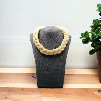 Chunky Yellow rope necklace shown on a dark bust model on a wooden worktop against a light background