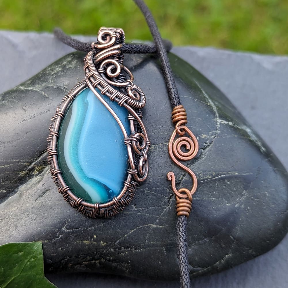 Handcrafted copper wire wrapped blue glass pendant with handmade fastenings