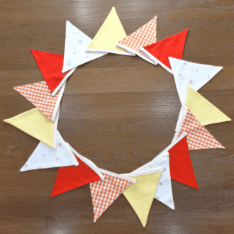 16 flag bunting in bright orange, yellow and ivory colours.
