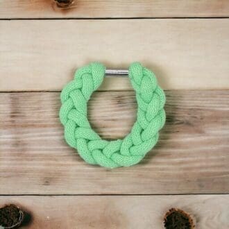 Neon green chunky rope bracelet shown agains a light wood background.