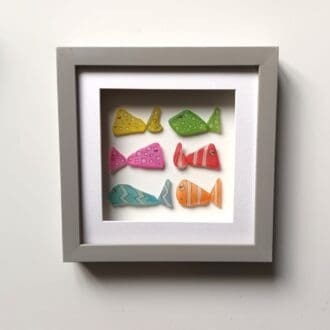 Six colourful spotty and stripy sea glass fish in a 24cm frame
