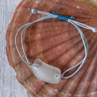 white seaglass bracelet sitting on shell