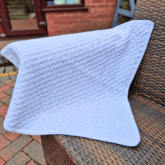 white baby blanket, crochet from cornjer to corner this blanket is the perfect size for a moses basket or covering your little one in their pram or car seat
