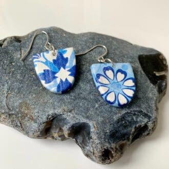 Arch shaped blue & white patterned drop earrings.
