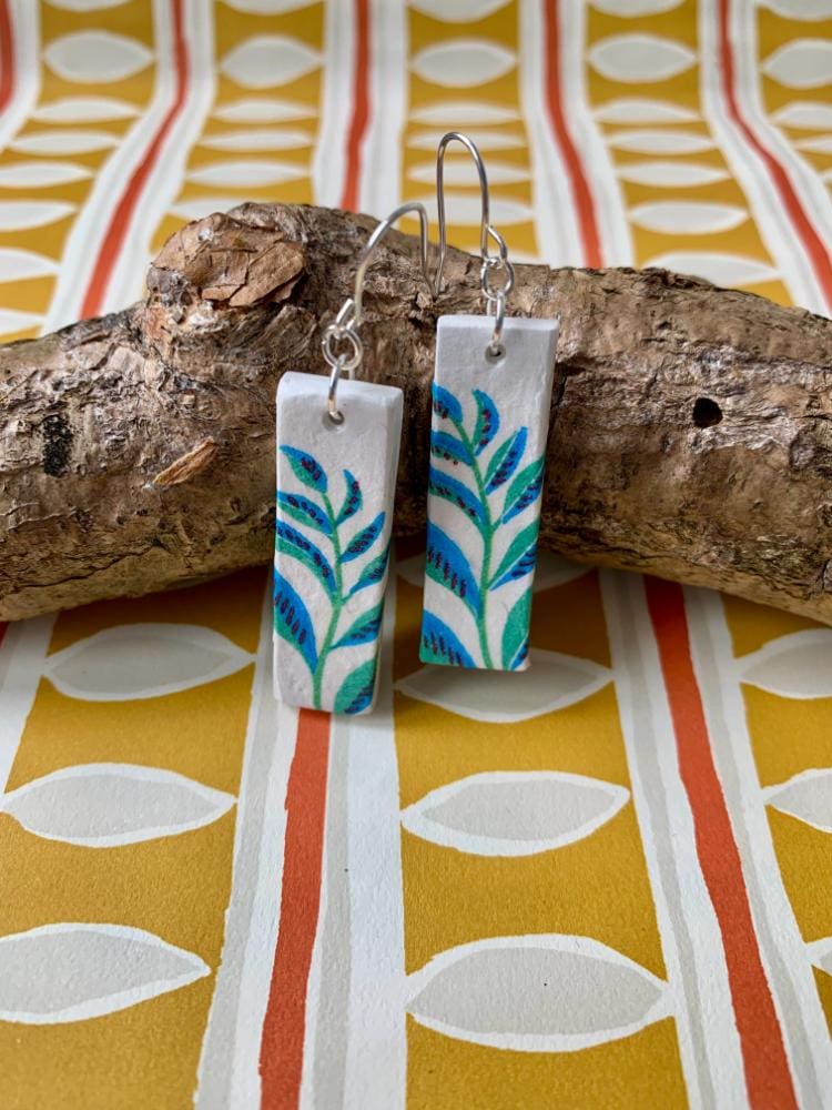 Stylish rectangle drop earrings decorated with a botanical pattern.