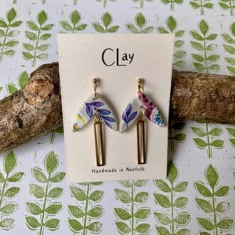 Leaf-shaped, colourful drop earrings. The floral pattern is mismatched to create a quirky vibe. A long gold-tone charm turns these earrings into a real statement, perfect for summer evenings.