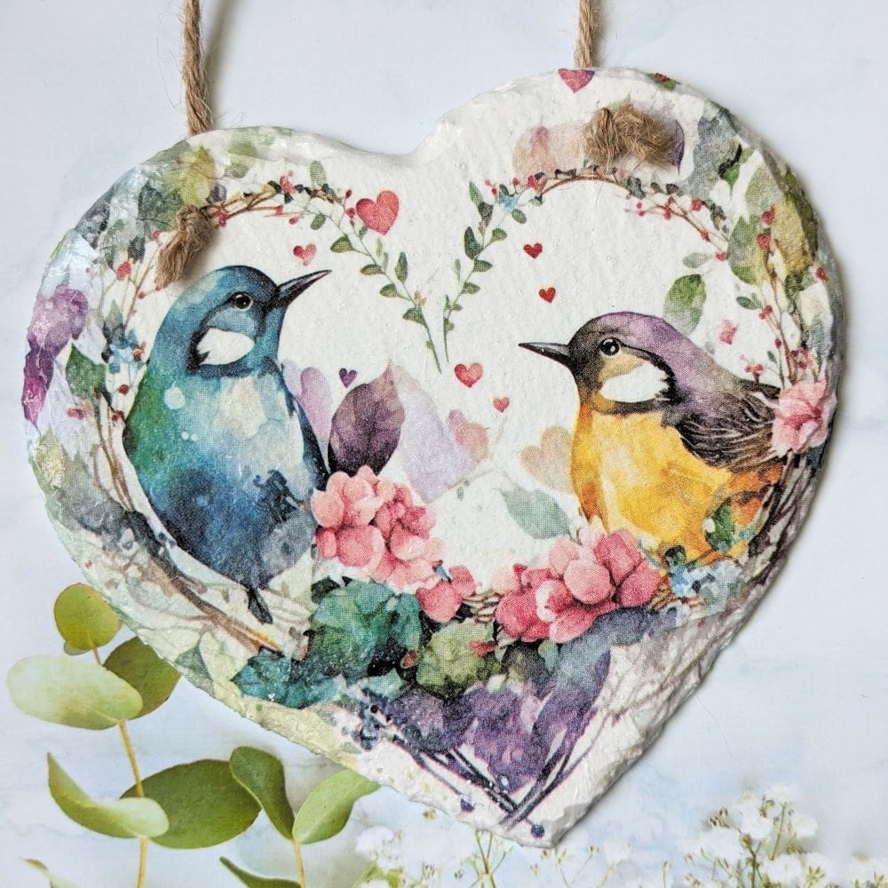Slate hanging heart, painted white and decoupaged with colourful love birds inside a floral heart. Finished with a twine hanger.