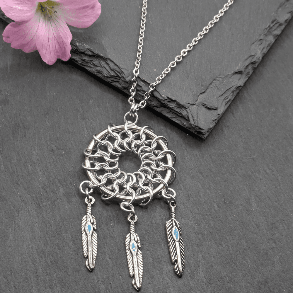 Chainamille pendant made in the shape of a dreamcatcher using aluminium rings and small feather charms on a 30 inch stainless steel chain