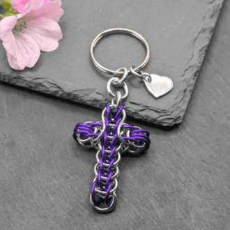 A keyring made with silver and purple coloured rings woven in the full persian chainmaille weave into a cross