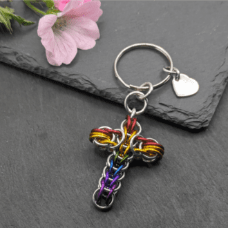 a keyring made with silver and rainbow coloured rings woven in the full persian chainmaille weave into a cross
