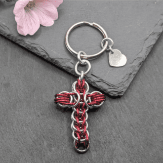 A keyring made with black and red coloured rings woven in the full persian chainmaille weave into a cross
