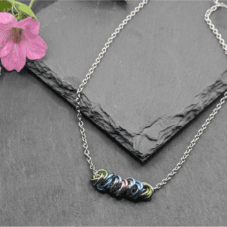 Seven chainmaille mobius units in pastel colours threaded on a stainless steel chain