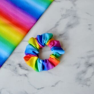 Blue, green, yellow, orange and purple rainbow coloured striped scrunchy