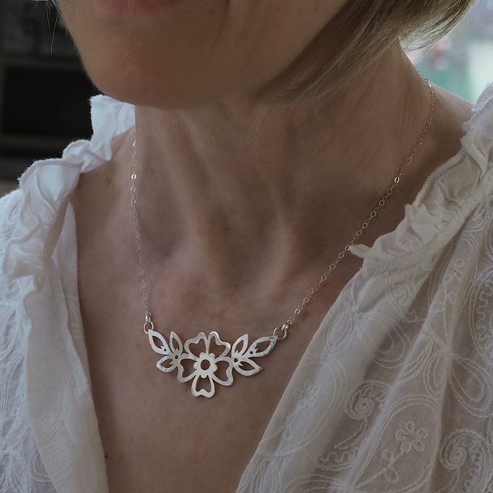 Hammered Cutwork Sterling silver flower and leaf motif pendant on a delicate flat trace chain modelled