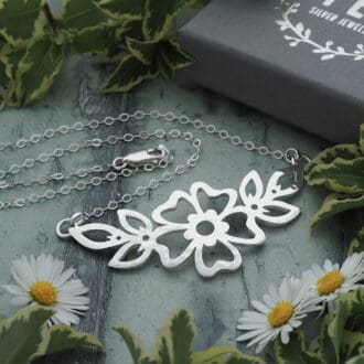 Hammered Cutwork Sterling silver flower and leaf motif pendant on a delicate flat trace chain