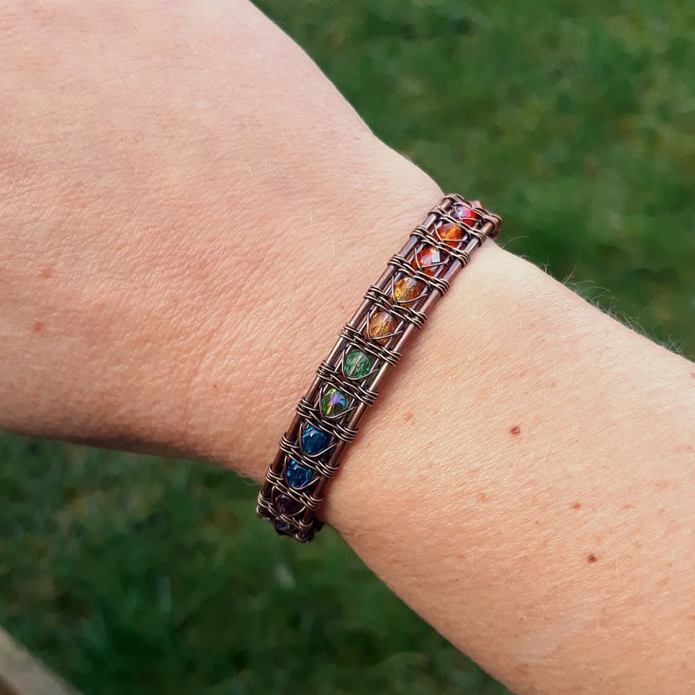 wrist wearing a copper wire weave cuff bracelet with rainbow beads by oruki design