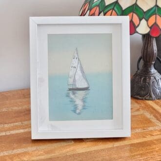 Original embroidery of a sailing boat on calm waters showing the reflection on the sea. 23 x 28 cm in total size including the frame.