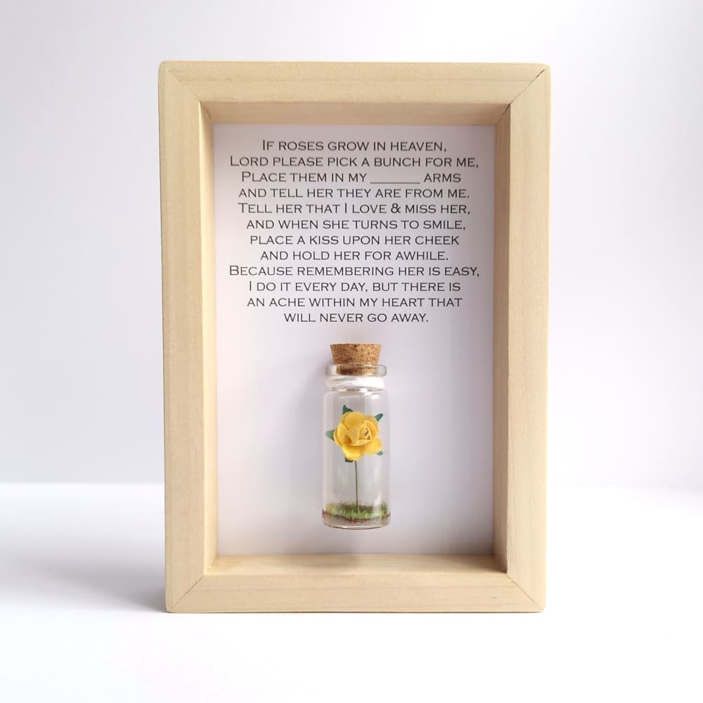Miniature yellow rose in a small glass bottle with a framed if roses grow in heaven quote