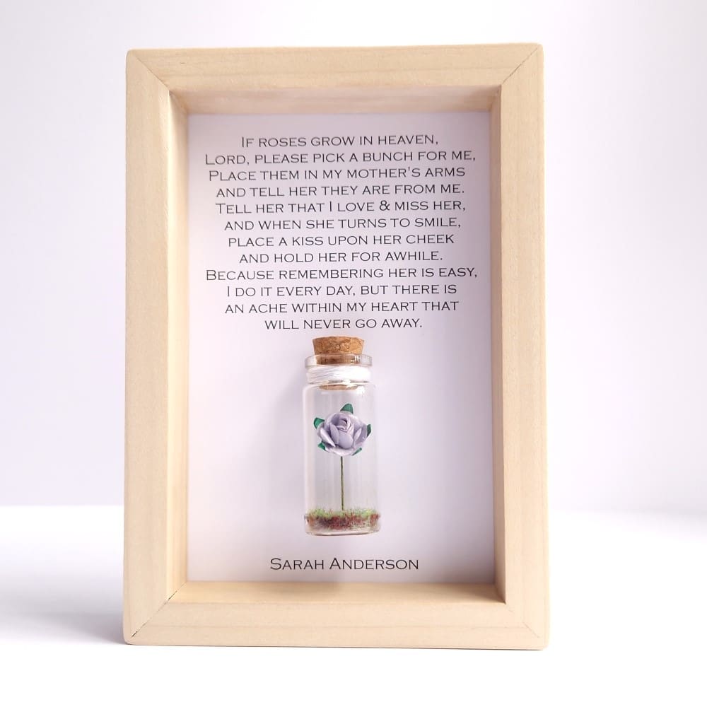 Lilac rose in a small glass bottle attached to a framed personalised memorial quote