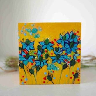 Hand painted gift box with Nigella flowers against a yellow background.