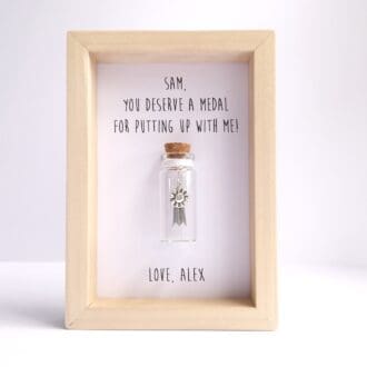 Small wood frame with a glass bottle insert and personalised medal quote