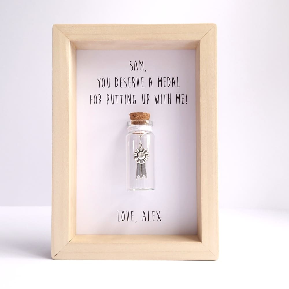 Small wood frame with a glass bottle insert and personalised medal quote