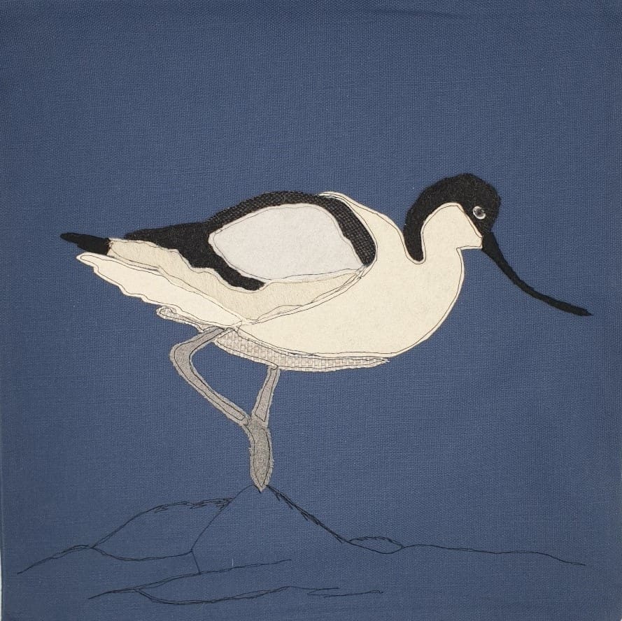 Appliqued Avocet on denim blue cushion