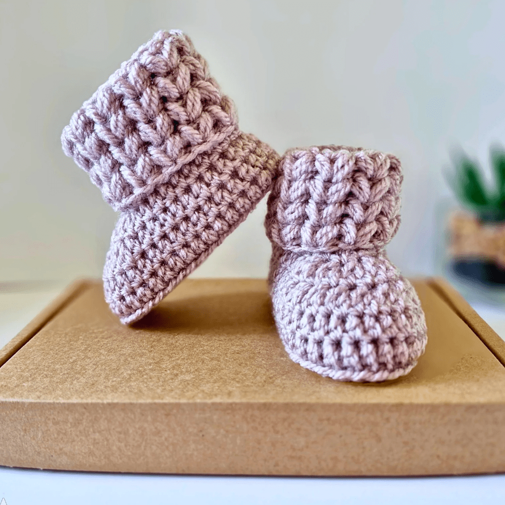 a pair of baby booties with a puff 'v' stitch cuff design in sizes newborn, 0-3 and 3-6 months with a large choice of colours available