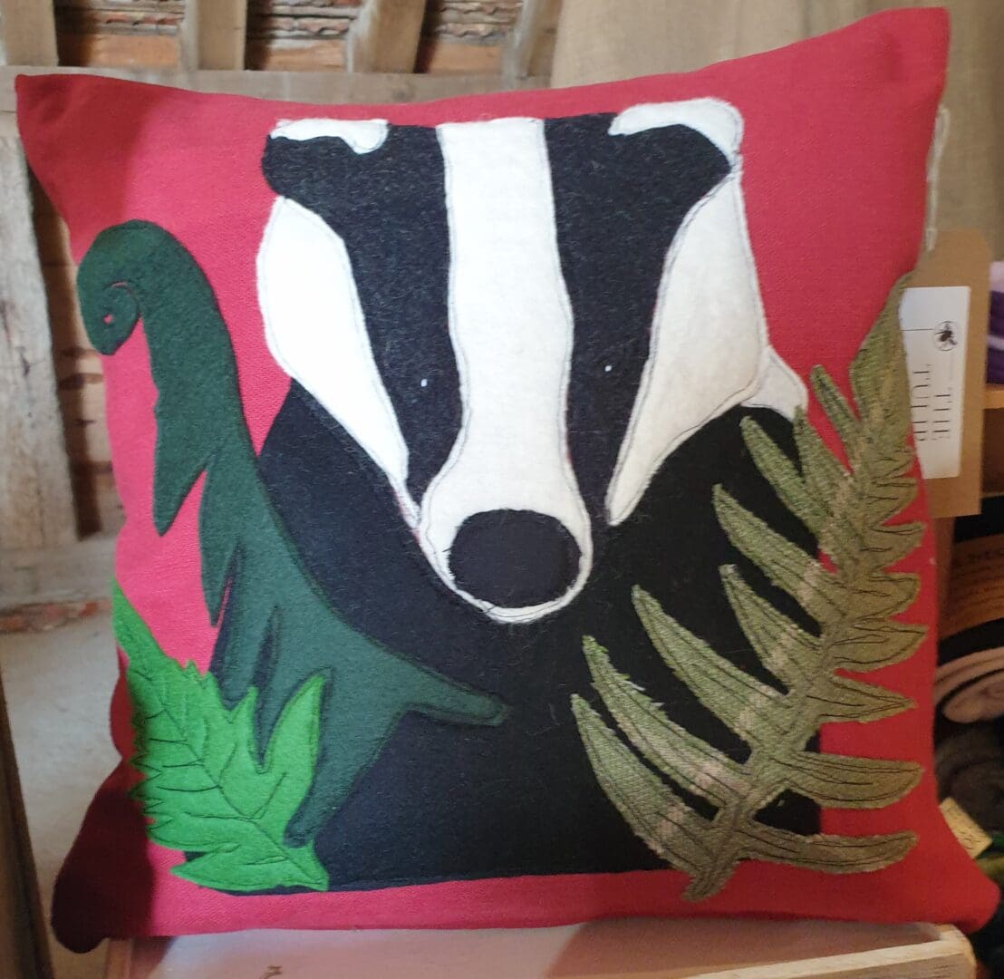 Appliqued Badger cushion on red cotton