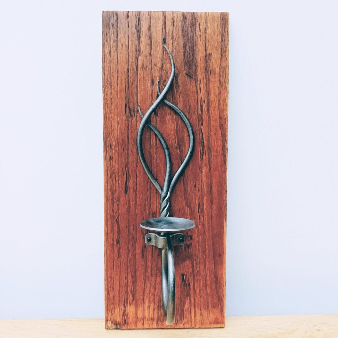 Hand forged sconce for a candle mounted onto reclaimed oak
