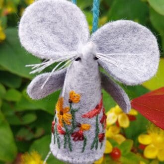 A hand embroidered and stitched felt mouse with a design of daisies.