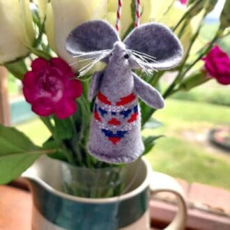 A handstitched felt mouse with a cross stitch heart in Red White and Blue