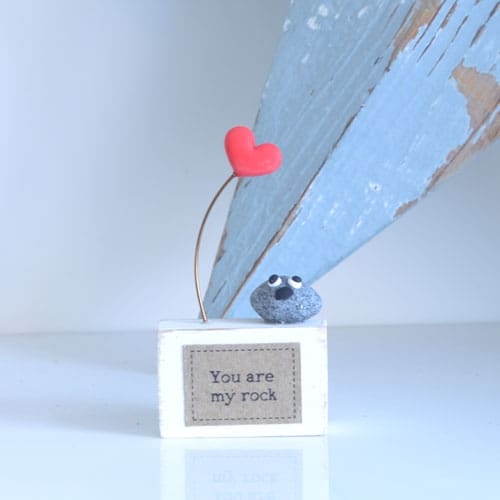 Small block of wood with a handmade clay rock and heart with 'You are my rock' to the front.