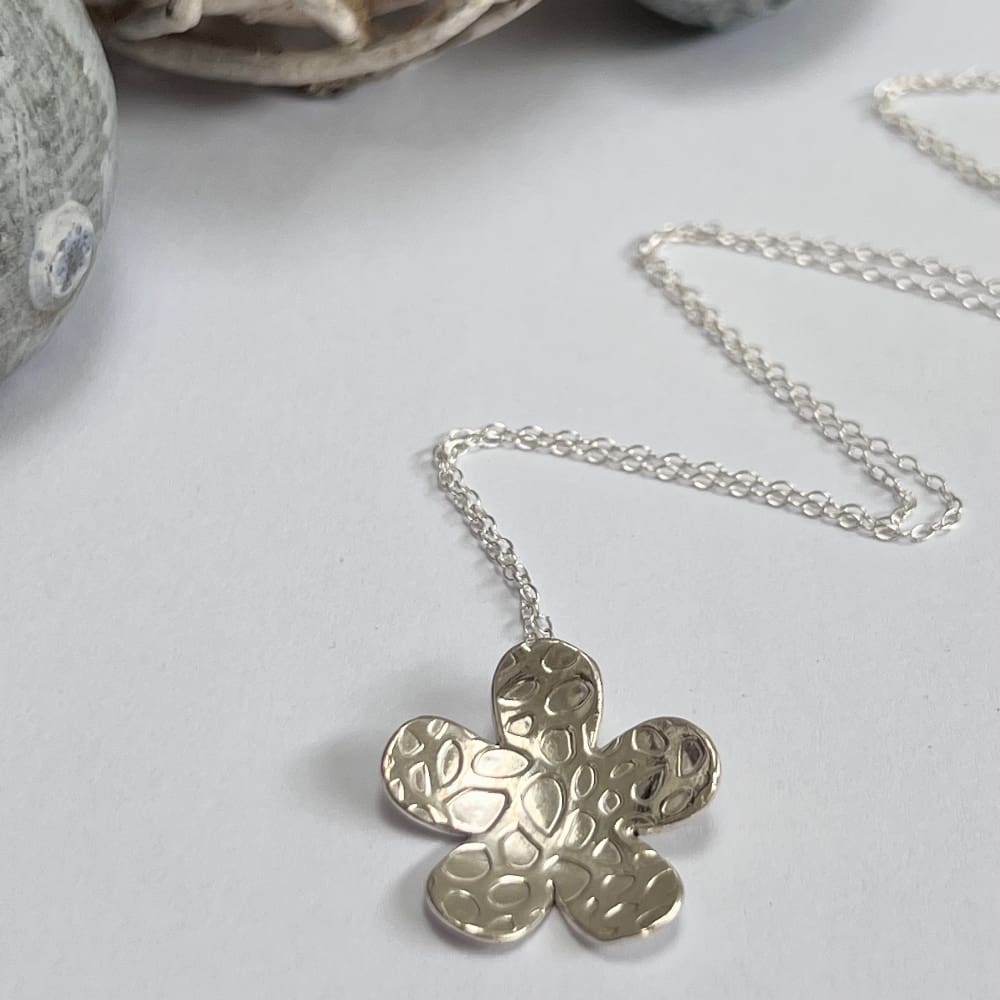 Large silver flower necklace. Textured and domed statement pendant