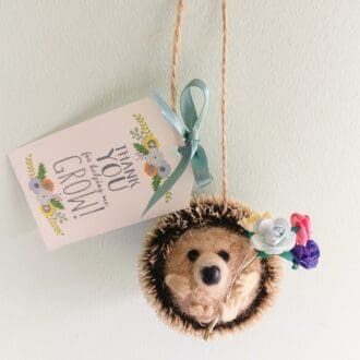 Hedgehog holding flowers with a gift tag