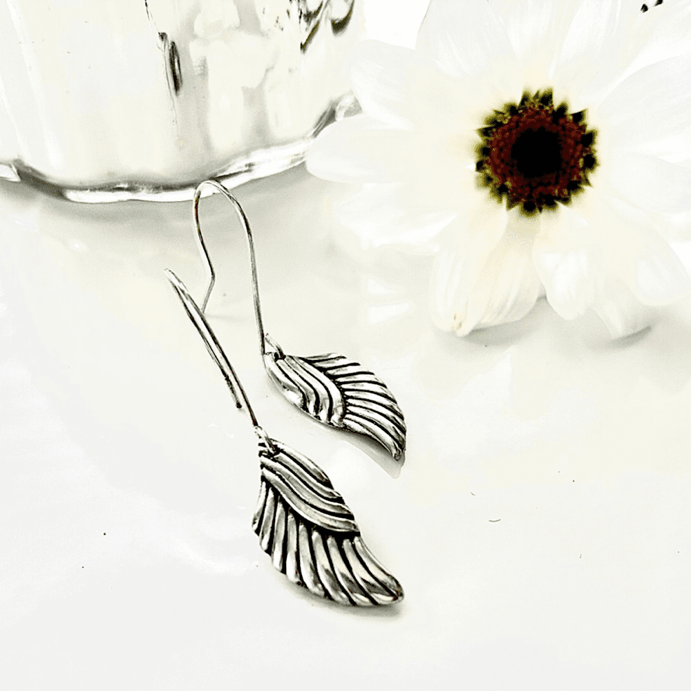 Silver earrings in the shape of angels wings with sterling silver ear wires.