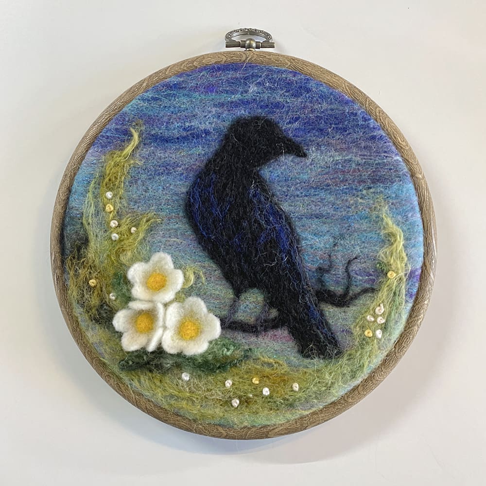 Needlefelted crow silhouette picture in a woodgrain effect hoop
