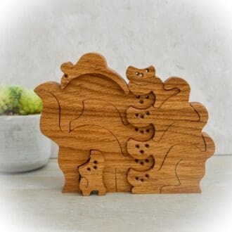 Eight Wooden Cats and One Mouse Cut from Oak. Stacked on top of each other.
