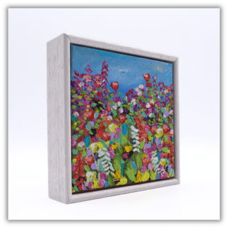 A small framed painting of colourful wildflowers.