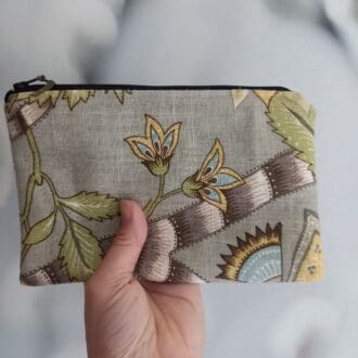 green floral line purse held up by hand