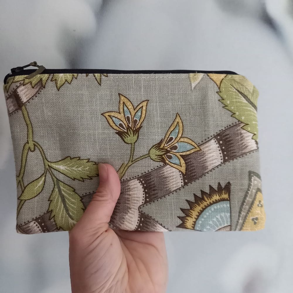 green floral line purse held up by hand