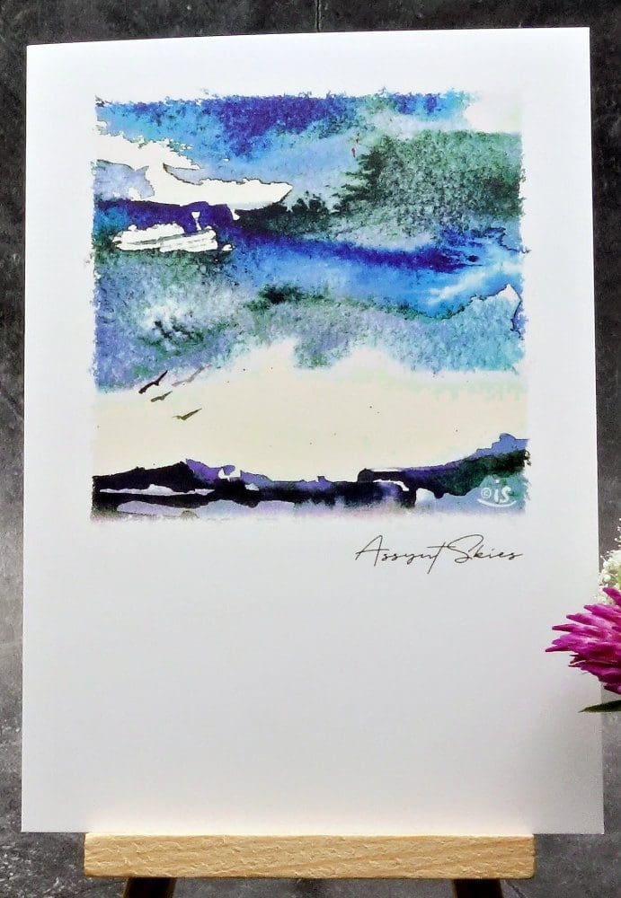 Larger image showing an A6 size greetings card, blank inside, on a small easel displaying an Assynt skyscape.