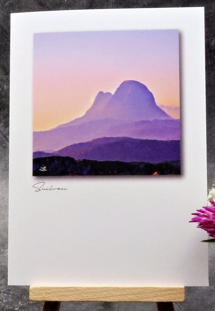 Larger image showing an A6 size greetings card, blank inside, on a small easel displaying a summer's evening view of Suilven in Assynt!